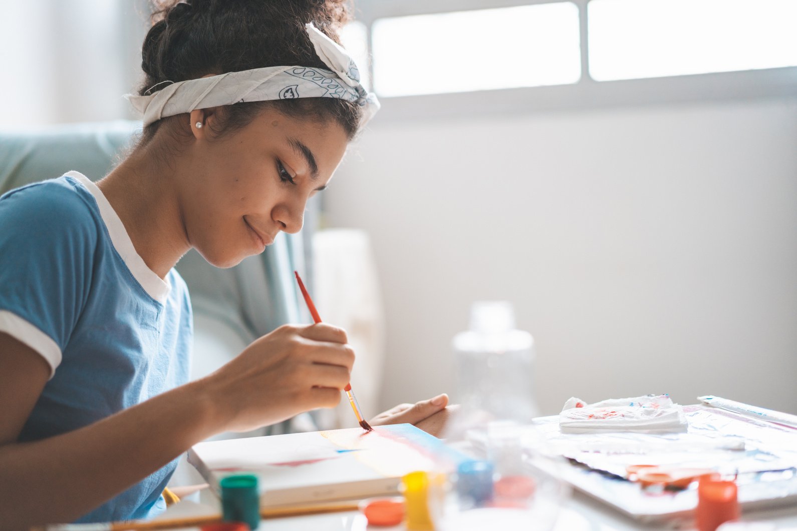 Teen girl painting at home